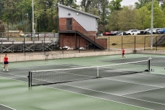 Addie Williams and Autumn Hinkley brave the damp courts early in the tournament