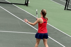Sydney Bacon fires a hot shot across the net as Autumn Hinkley runs across court to retrieve a ball in the background